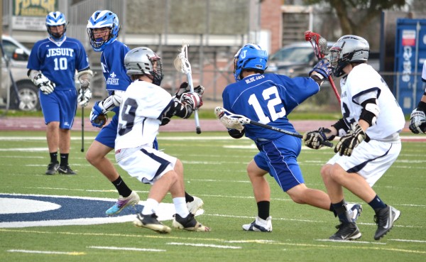 Sophomore Billy McMahon rolls away from the St. Thomas More double to preserve possession of the ball.