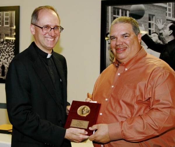 Fr. Raymond Fitzgerald, S.J., president of Jesuit High School, presents the second 2013 Profile Award to theology teacher Chris LaMothe.