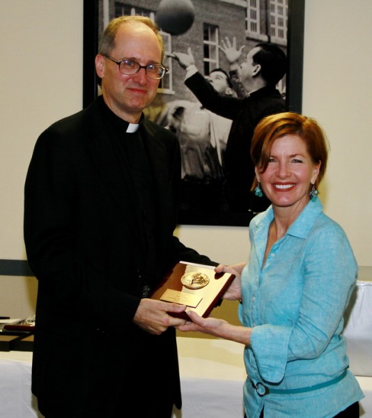 Fr. Raymond Fitzgerald, S.J., president of Jesuit High School, presents the third 2013 Profile Award to guidance director Mollie Roberts.