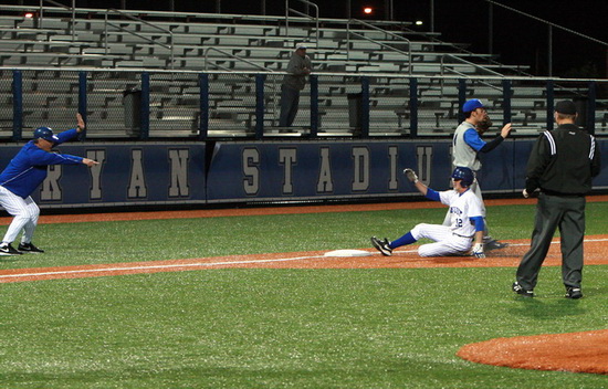 Take Your Base! Jesuit head coach Joey Latino (left) stops sophomore designated hitter Ben Hess (12) at third base. Ben’s triple clears the bases and begins a scoring barrage which eventually led to the imposition of the 10-run rule in the fifth inning. Jesuit wins over Mandeville, 11-0. 