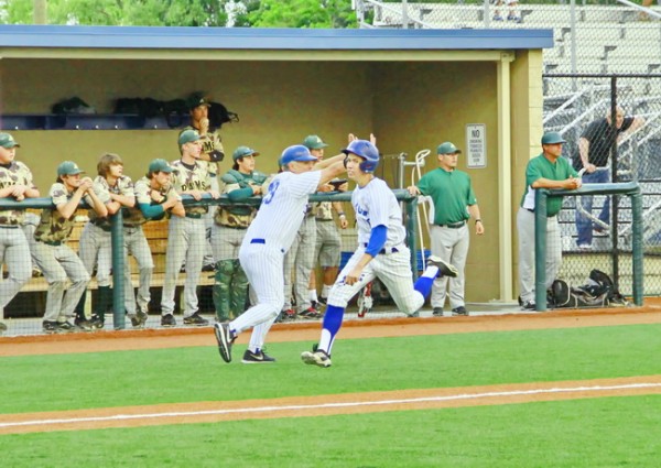 Junior shortstop Brandon Sequeira flies home to score Jesuit’s only run in the opening game of the state playoffs against the Acadiana Rams on Wednesday evening, May 1, at John Ryan Stadium. Coach Joey Latino holds senior Mitch Alexander at third base.