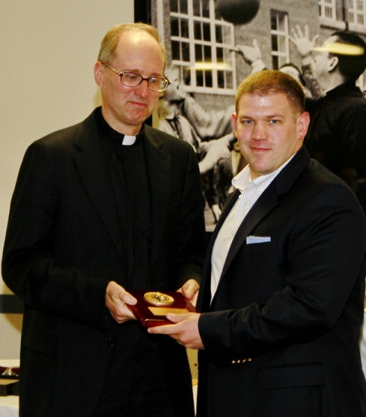 Fr. Raymond Fitzgerald, S.J., president of Jesuit High School, presents the first 2013 Profile Award to theology teacher Matt Orillion ’98.