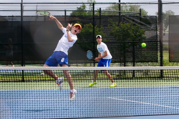 Sophomore Gregory Suhor jumps high for this “kill shot” while teammate, junior Kevin Mickan, stands guard in the back court during their doubles match against Destrehan on Monday, April 22, the opening day of the LHSAA  Regional Tournament at UNO. 