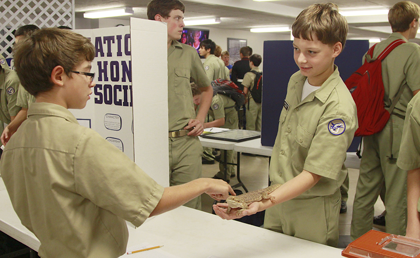 Herpetology Club member and pre-freshman Christopher Womble introduces pre-freshman Christian Butler to a bearded dragon.