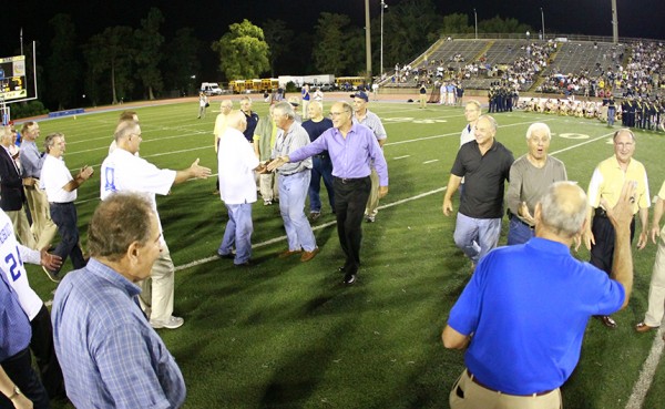 Members of the 1963 Holy Cross and Jesuit teams meet on the field during halftime as they are honored as the 2013 Legends of the Game.