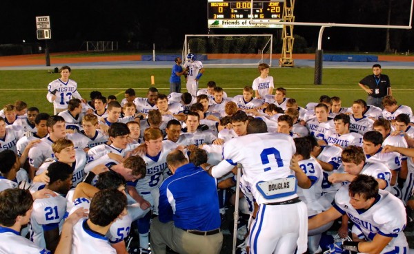 Jesuit coach Wayde Keiser and his team of Blue Jays take a knee in prayerful thanks following a well-deserved "20-nothing" shutout of Brother Martin on Friday night at Tad Gormley Stadium.