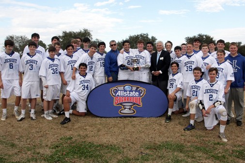 Members of the 2014 Jesuit Lacrosse team pose for a photo of winning the Allstate Sugar Bowl Tournament championship trophy.