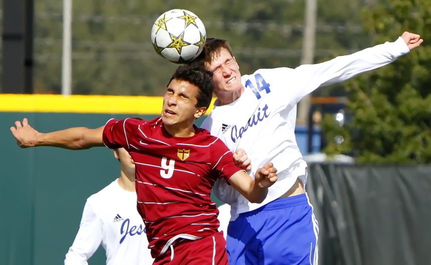 Jesuit senior Will McQueen goes up head-to-head against this Crusader in a Saturday soccer match at John Ryan Stadium that proved to be a tough physical battle for both teams.