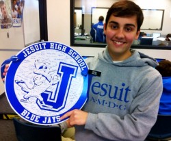 Sophomore David Keller displays the token of appreciation that the sophomore class presented to Jesuit security guard James Allen on his last day of service at Carrollton and Banks.