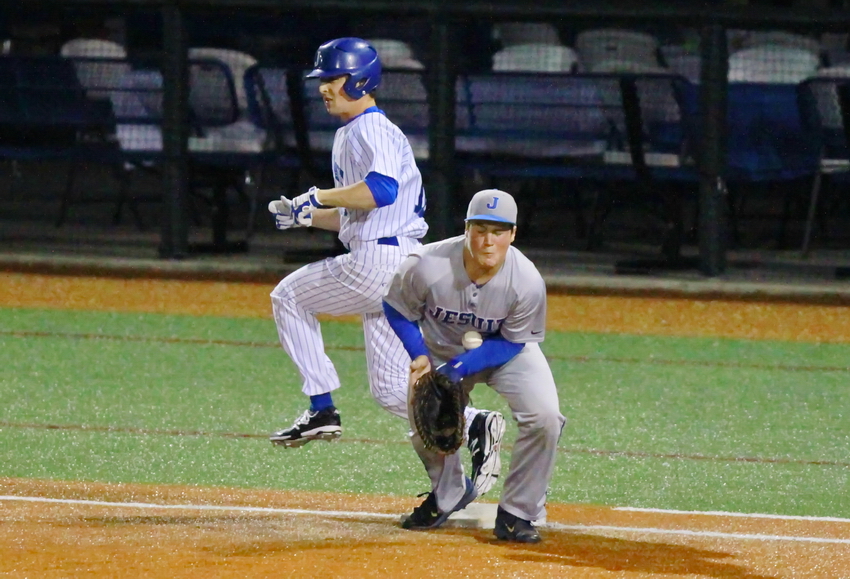 Junior outfielder Ben Hess is safe at first as the Jesuit Tampa Tiger juggles the throw.