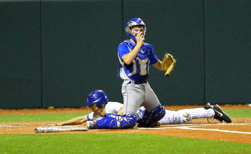 Andy Galy slides head-first into home as Mandeville's catcher juggles the throw from right field. Galy, on second base after a single and a steal, scored Jesuit's first run when catcher Trent Forshag blasted a double into right field in the bottom of the fourth inning of Saturday night's game against the Mandeville Skippers. The game, which Jesuit won, 3-0, closed out the 3rd Annual Jesuit Invitational Tournament at John Ryan Stadium.