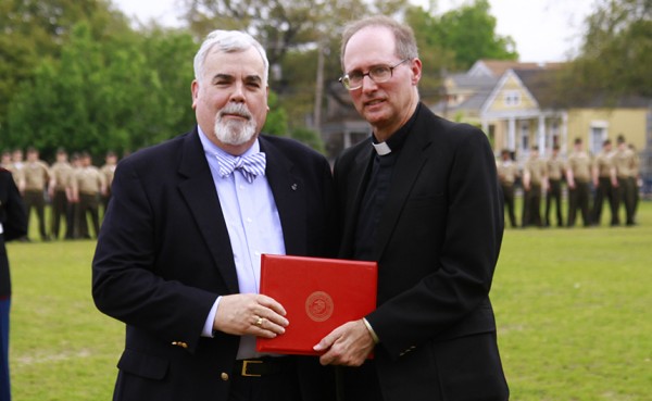Mr. Timothy Powers, this year’s MCJROTC Parade and Review honoree, receives his citation from Jesuit President Fr. Raymond Fitzgerald, S.J. '76.