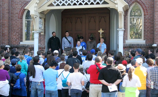 At the 2013 Nine Churches Walk, the pilgrimage stops at Our Lady of Good Counsel Church on Louisiana Avenue as  Brandon Briscoe ’98 provides tidbits of information about each of the churches visited.