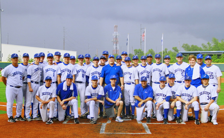 With a dark sky looming in the background, the 2014 Jesuit baseball team is joined by Blue Jay alumnus John Ryan '70 for a photo at home plate. The Jays bring a 32-5 record to the LHSAA State Tournament where they will play the 10th-seeded Eagles of Live Oak in the semifinal game on Friday, May 16 at 4 p.m.