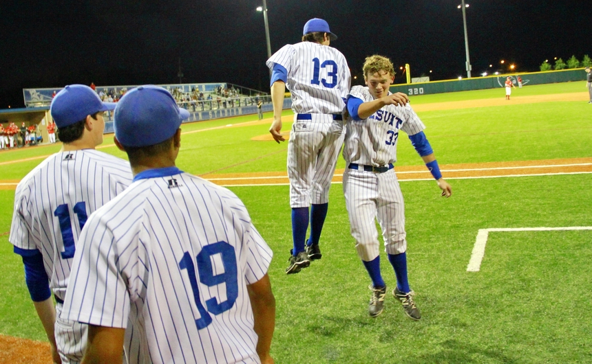 Trent Forshag (33) returns to the dugout after belting a double and celebrates with Nathan Zimmer (13), and pitchers Jack Burk (11) and Jordan Spann.