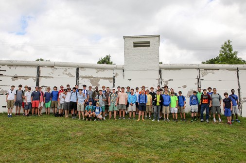 Student members of the Blue Jay Band pose in front of the "Wall" in Mödlareuth, where the original wall that divided the city and the country for almost 30 years still stands.