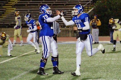 Offensive lineman Emerson Wenzel (79) congratulates quarterback Trey LaForge after he faked a handoff and kept the ball himself, skirting end for a 2-yard touchdown, the Jays' second TD against St. Augustine in last week's playoff game.