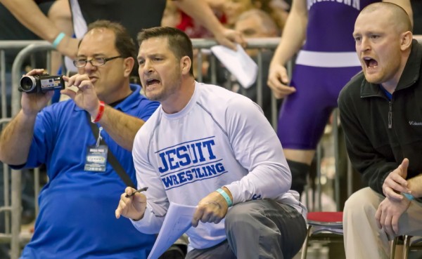Spencer Harris '89 (middle), shown here at the 2013 state tournament, is giving up his position as head coach of Jesuit wrestling to devote more time to his family and fatherhood. 