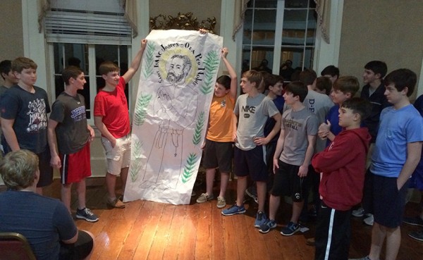 Freshmen display a poster of their grade level patron saint, St. Isaac Jogues, at the annual Sodality of Our Lady Retreat.