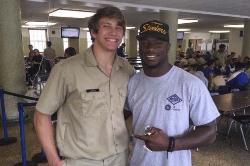 Senior Foster Moreau visits with Deion Jones '12 on April 9, in the Jesuit cafeteria. Moreau was the starting tight end on Jesuit's 2014 state championship football team. Jones, who played linebacker for the Jays, is a special teams standout and outside linebacker at LSU. Moreau will join Jones in the LSU football program in the fall.