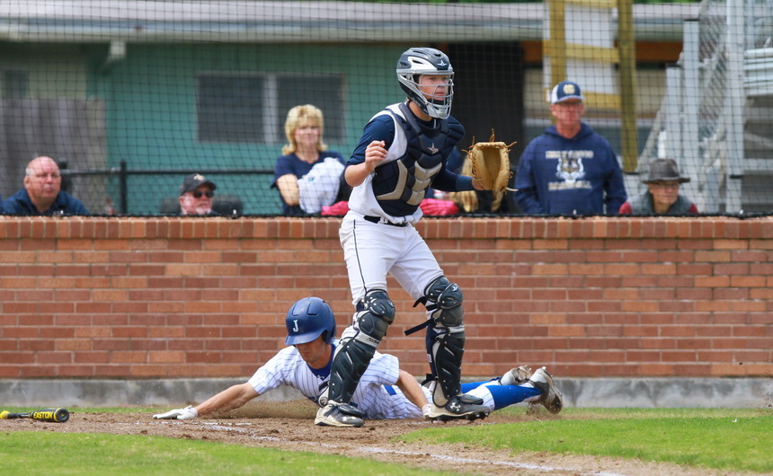 Ben Hess slides safely home to score Jesuit's first run.