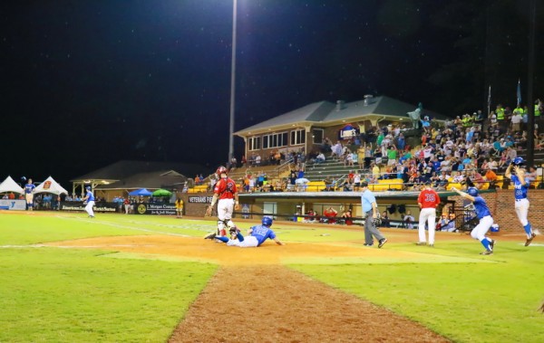 In the bottom of the 10th, the Oilers have the bases loaded with one out when Trent Forshag smashes a grounder to left field. Nick Ray (far right) easily scores the tying run from third base. Connor Maginnis, who was on second base as a pinch runner, dives for home and plates the winning run. In the distance on the left is Forshag, who is already celebrating Retif's 4-3 walk-off win against Brooklawn in the featured semifinal game at the American Legion World Series.