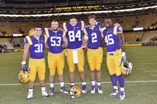 Blue Jays on the 2015 LSU football team huddle after the Tigers defeated Eastern Michigan. From left are: Bennett Schiro '13, Grant Leger '11, Foster Moreau '15, Trey LaForge '15, and Deion "Debo" Jones '12.