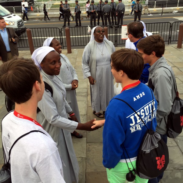 Jesuit pilgrims enjoy a moment of conversation with a few joyful religious sisters from Kenya.