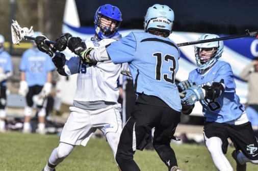 Senior attacker and team captain Max Murret (15) winds up and shoots between two defenders to score against Spain Park on Saturday, Jan. 23, 2016. The Jays won the game, 13-10.
