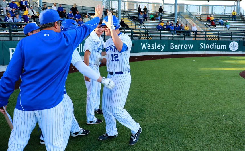 Nick Ray is congratulated by coaches and teammates as he returns to the dugout following a leadoff home run in the first inning of Jesuit's season opener on Thursday, Feb. 25. Mason Mayfield, with a towel draped over his neck, is all smiles because he was on his way to pitching a complete game.