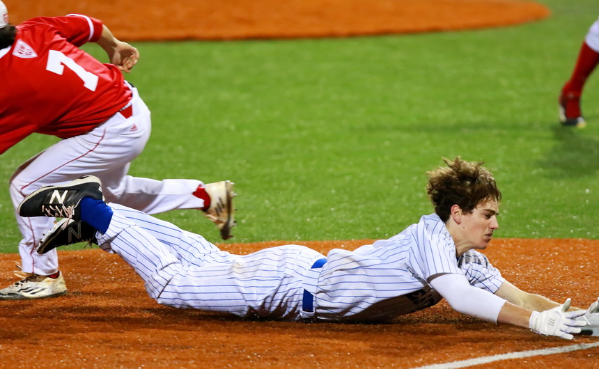 Connor Maginnis belly slides into third base for a triple that brought in a run.