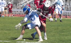 Junior attacker Noah Martin fights off a defender as he chases down a ground ball.