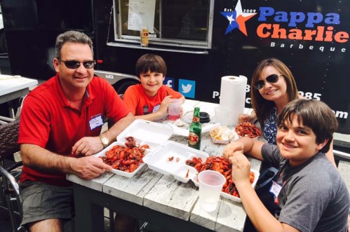 The Pfister Family -- David '78, David, Maria, and Derek -- enjoy the mudbugs at the 2015 Houston Alumni Chapter Crawfish Boil.