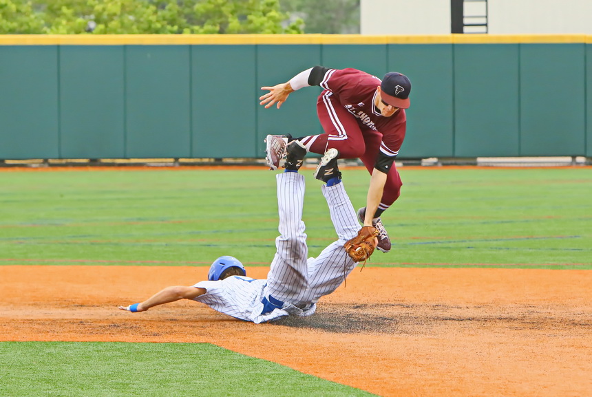 Bryce Musso belly slides to safely steal second base as the Falcons' shortstop goes up and over on the play.