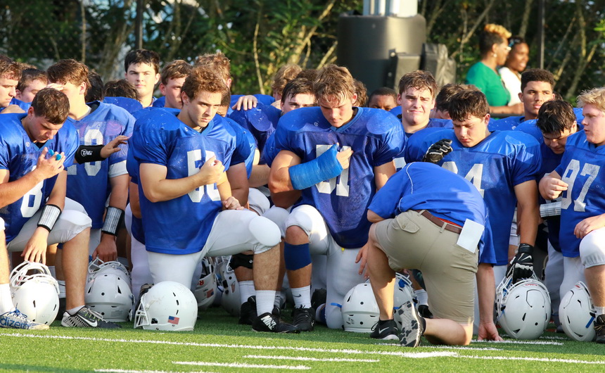Coach Mark Songy leads the Blue Jays in prayer shortly after the spring game concluded.