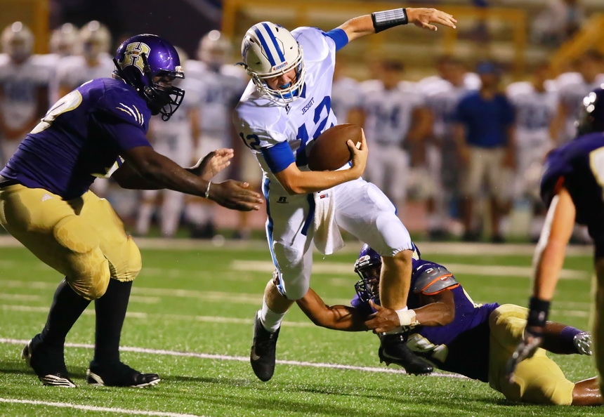 Quarterback Alex Watermeier can't find an open receiver and is thrown for a four-yard loss while trying to elude a trio of Tiger defenders in the Hahnville Jamboree.