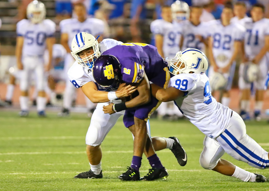 Sophomore Perry Ganci and freshman Marquis Martin (99) drag this Purple Knight runner down.