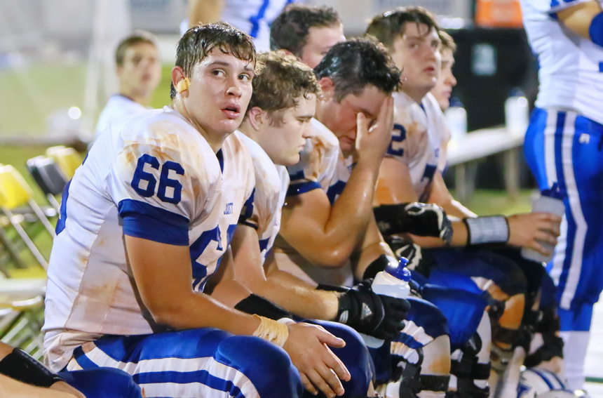Cameron Maheu (66) and his offensive line teammates take a break late in the game.