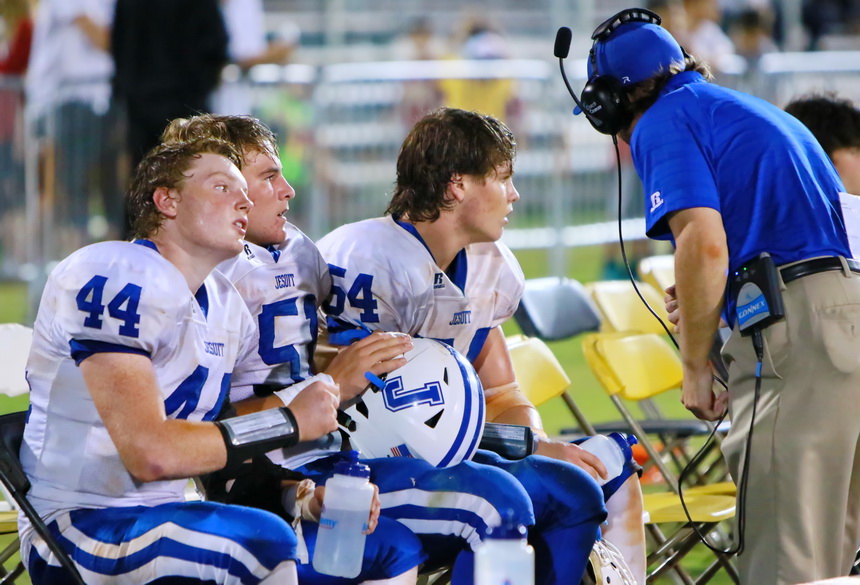 Jesuit linebackers Jacob Baxter (44), Hunter Faust (51), and Cameron Crozier (54) have a chat late in the game with assistant coach Danny DeVun '08.