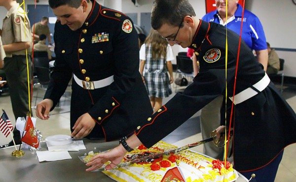From right, Cadet LtCol. John Crowson (senior) and Cadet SgtMaj. Travis Kieff (senior) cut and pass out the cake during the birthday ceremony.