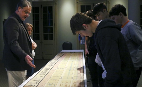 Curator d Margot shows students the survey of land on which the second Ursuline Convent stood in the 1840s.