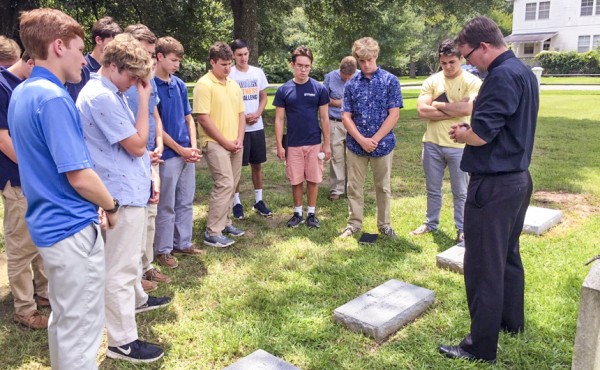 Fr. Kevin Dyer, S.J. leads the Francis Borgia retreatants in prayer over Fr. Raymond Fitzgerald, S.J.'s tomb.