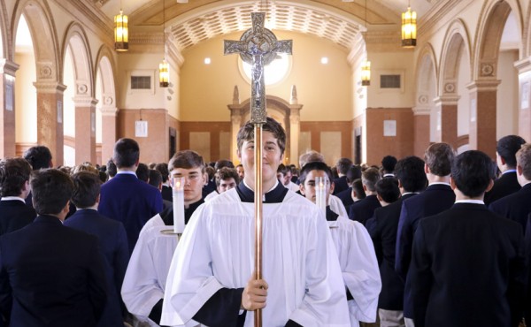 The altar servers, led by senior John McMahon, lead the procession out of Mass.