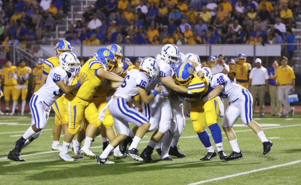 The entire Jesuit defense swarms in for the tackle.