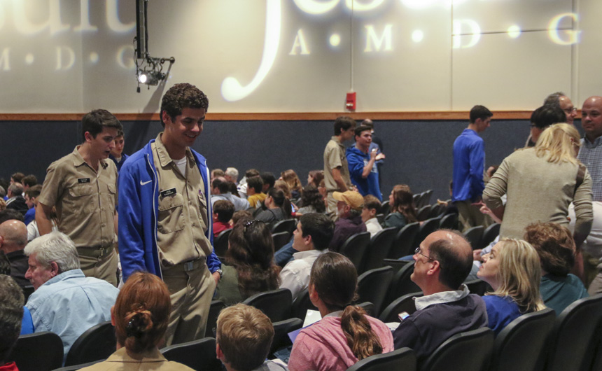 Jack Baudouin chats with a visiting family before the program begins in the auditorium.