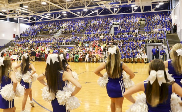Cheerleaders perform at the start of the pep rally as students take their seats.