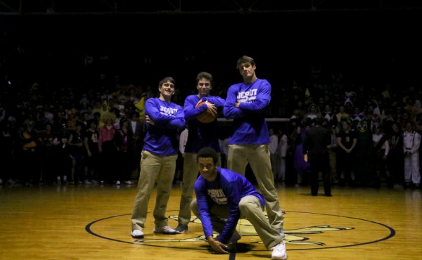 Seniors on the basketball team pose for a photo at half-court. (From left, standing) Patrick Schwing, Will Landrieu, and Drew Black. Kneeling is Michael Hull.
