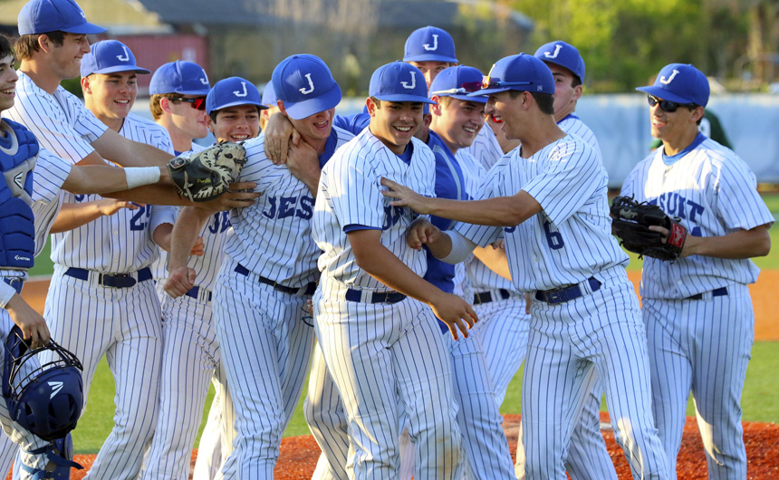 The team celebrates with pitcher Andrew Cashman after winning the elimination game over Shaw at John Ryan.