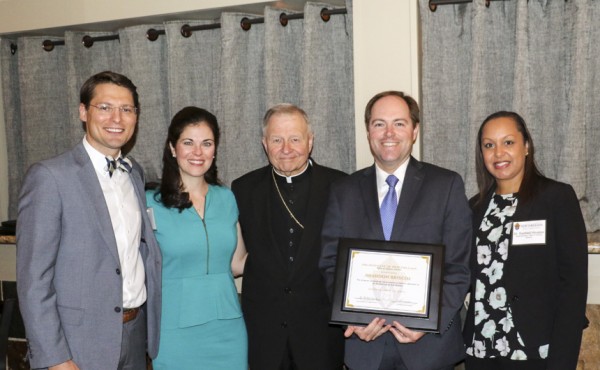 Archbishop Gregory Aymond and Dr. RaeNell Houston, the superintendant of Catholic Schools, present the Distinguished Alumnus Award for Jesuit to Brandon Briscoe '98. Brandon was accompanied by his wife Sarah Jane, and Jeremy Reuther represented the school.
