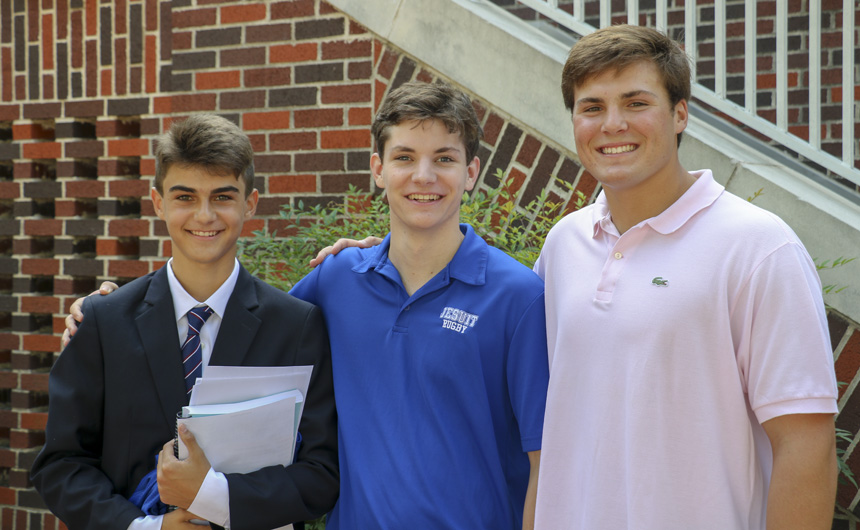 Senior class president Langston Goldenberg (right) greets William Newell and his little brother Scout Hughes (left).